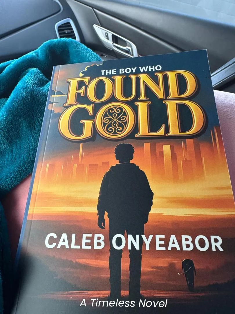 Reader holding The Boy Who Found Gold novel by Caleb Onyeabor in Los Angeles, California - inspirational fiction book