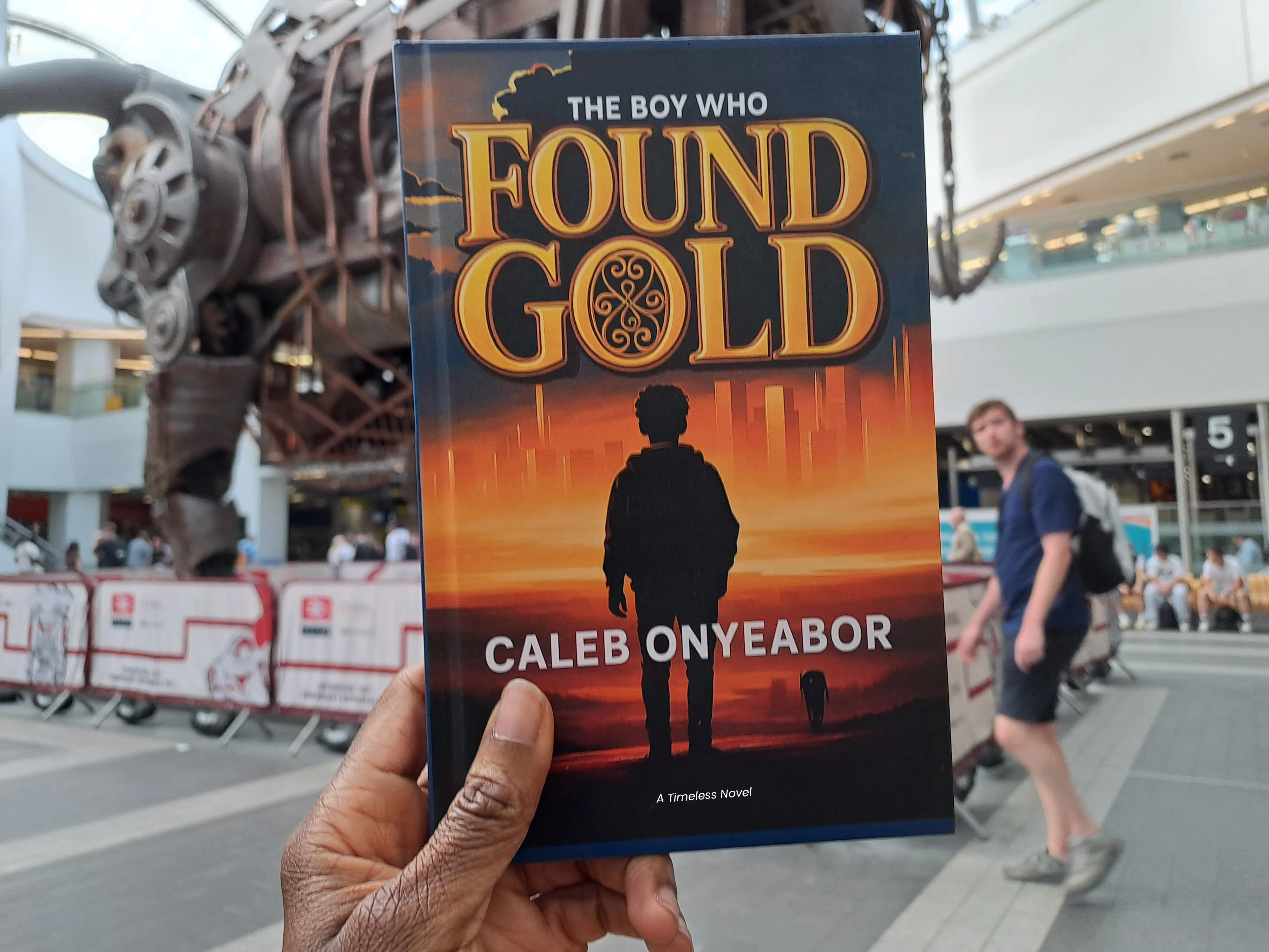 Reader with The Boy Who Found Gold novel by Caleb Onyeabor in United Kingdom - motivational fiction book about dreams